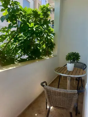 a table and two chairs next to a plant at Rooms Ajllin in Ulcinj