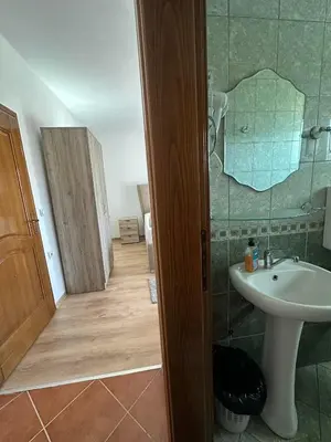 a bathroom with a sink and a shower with a mirror at Rooms Ajllin in Ulcinj