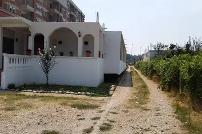 a dirt road next to a white house at Rooms Ajllin in Ulcinj
