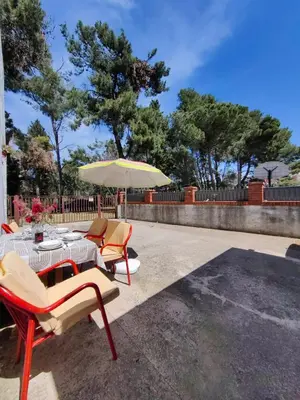 a table with chairs and an umbrella on a patio at BOR - The Entire Home with Sea view in Ulcinj