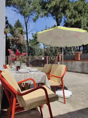 a table and chairs with an umbrella on a patio at BOR - The Entire Home with Sea view in Ulcinj