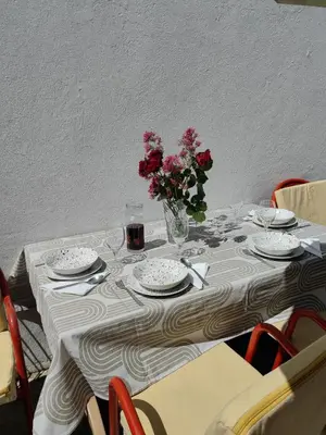 a table with plates and a vase of flowers on it at BOR - The Entire Home with Sea view in Ulcinj