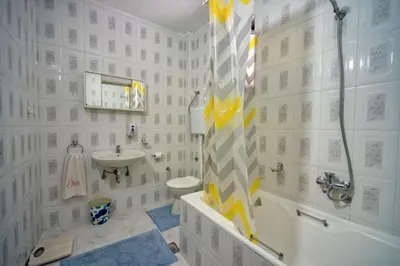 a white bathroom with a shower and a sink at BOR - The Entire Home with Sea view in Ulcinj