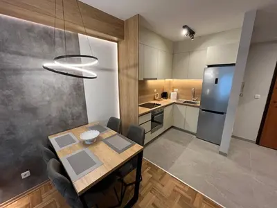 a small kitchen with a table and a refrigerator at Apartments 28 in Podgorica