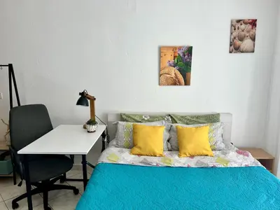 a bedroom with a bed with yellow pillows and a desk at Studio Lucica in Petrovac na Moru