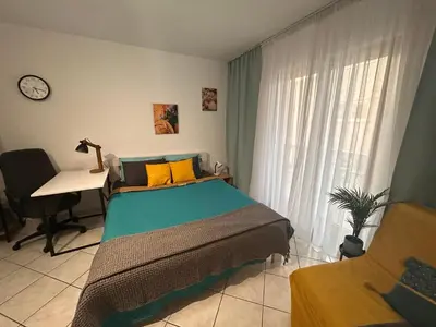 a bedroom with a bed and a desk and a window at Studio Lucica in Petrovac na Moru