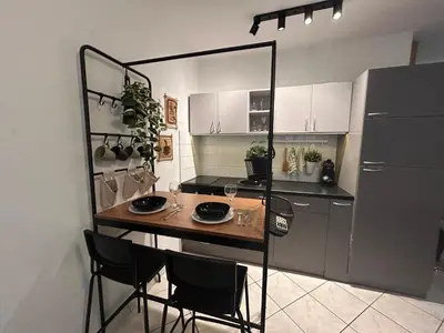 a kitchen with a table and chairs and a refrigerator at Studio Lucica in Petrovac na Moru