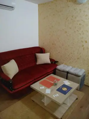 a living room with a red couch and a coffee table at Apartments Popovic in Podgorica
