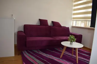 a living room with a purple couch and a table at Mateja&Fontana Apartment in Budva