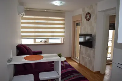 a small living room with a table and a window at Mateja&Fontana Apartment in Budva