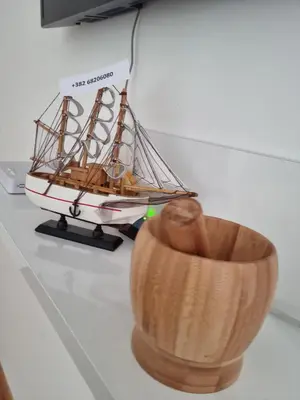 a model boat sitting on a counter next to a wooden bowl at Mateja&Fontana Apartment in Budva