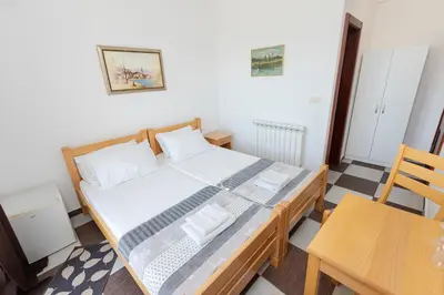 a small bedroom with a bed and a table and chairs at Guest house Vila Vedesa in Kotor