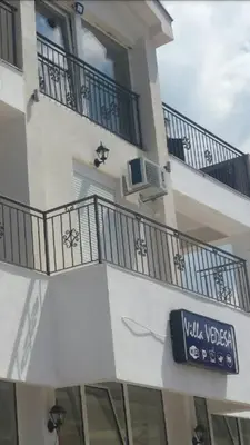 a white building with balconies and a sign on it at Guest house Vila Vedesa in Kotor