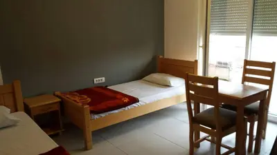 a bedroom with a bed and a table and a chair at Guest house Vila Vedesa in Kotor
