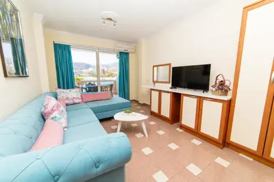a living room with a blue couch and a tv at Ponta in Rafailovici