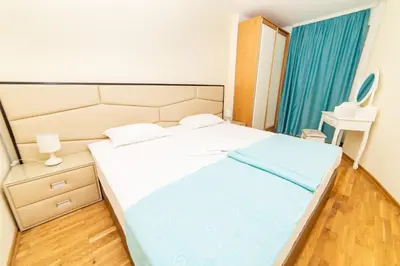 a bedroom with a large bed with blue sheets at Ponta in Rafailovici