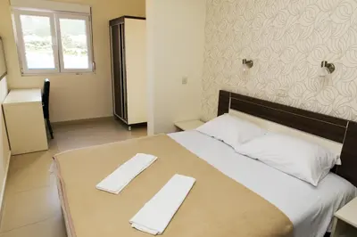 a bedroom with a large bed with two napkins on it at Ponta in Rafailovici