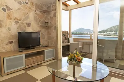 a living room with a tv and a glass table at Ponta in Rafailovici