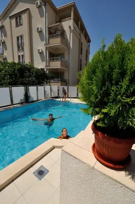 two people swimming in a swimming pool in a building at Vila Đurić - Ex Hotel Đurić in Petrovac na Moru