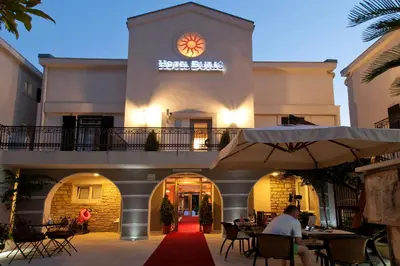 a hotel with a red carpet in front of a building at Vila Đurić - Ex Hotel Đurić in Petrovac na Moru
