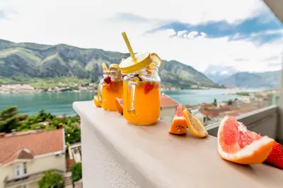 a couple of jars of juice and fruit on a ledge at Apartments Magic Sea View in Kotor