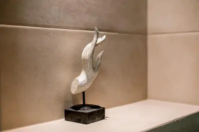 a statue of a bird on a stand on a shelf at Apartments Magic Sea View in Kotor