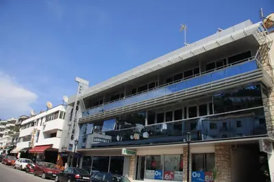 a tall building with cars parked in front of it at Accommodation Dolcino in Ulcinj