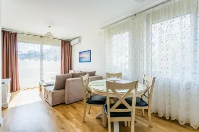 a living room with a table and chairs and a couch at Apartments LORA Cetinjska in Budva