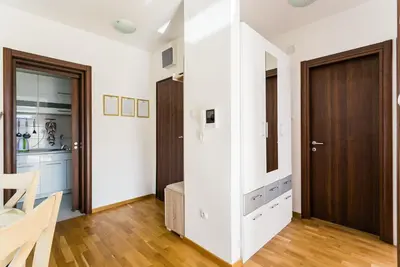 a room with white walls and a wooden door at Apartments LORA Cetinjska in Budva