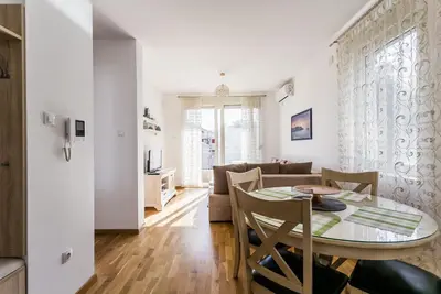 a dining room and living room with a table and chairs at Apartments LORA Cetinjska in Budva
