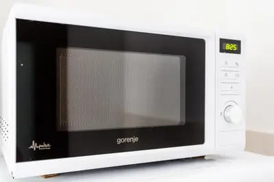 a white microwave oven sitting on top of a counter at Apartments LORA Cetinjska in Budva
