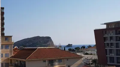 a city with buildings and a mountain in the background at Pjerotic Apartment in Budva