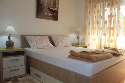 a bedroom with a bed with a blanket on it at Pjerotic Apartment in Budva