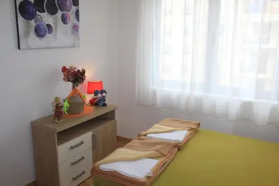 a bedroom with a bed and a dresser and a window at Pjerotic Apartment in Budva
