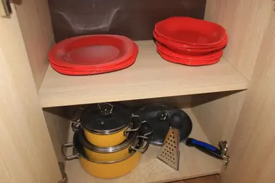 two red plates and a pot on a shelf at Pjerotic Apartment in Budva