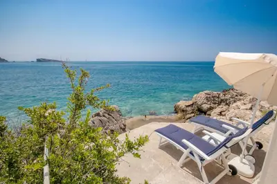 a couple of chairs and an umbrella on the beach at Luxury Villa Alena in Utjeha