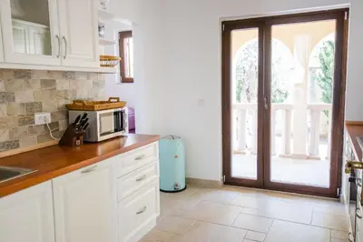 a kitchen with white cabinets and a microwave at Luxury Villa Alena in Utjeha