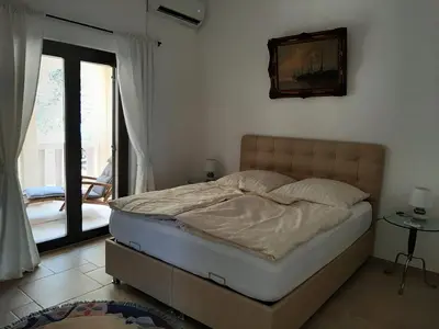a bedroom with a bed and a door to a balcony at Luxury Villa Alena in Utjeha