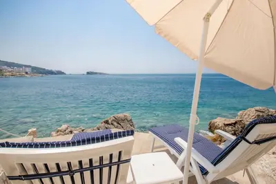 two chairs and an umbrella on the beach at Luxury Villa Alena in Utjeha