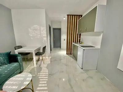 a kitchen and living room with a couch and a table at Etna Apartments in Ulcinj