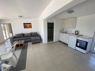 a kitchen and a living room with a couch and a table at Etna Apartments in Ulcinj