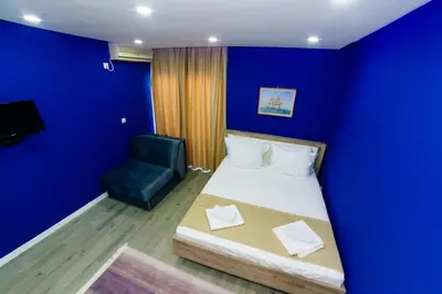 a blue room with a bed and a chair at Etna Apartments in Ulcinj