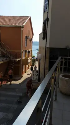 a group of people walking down a street next to a building at M&M Apartman 2 in Rafailovici
