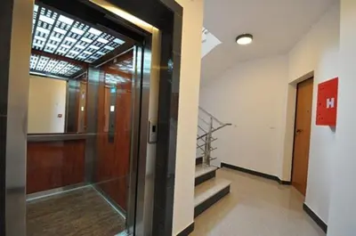 a hallway with a glass door and stairs in a building at M&M Apartman 2 in Rafailovici
