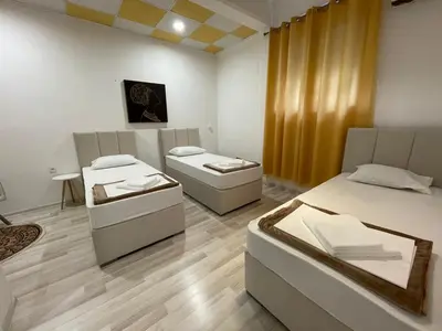 a room with two beds and a couch in it at Hostel Izvor in Podgorica