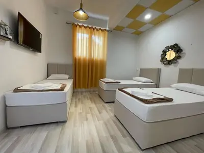 a room with two beds and a flat screen tv at Hostel Izvor in Podgorica