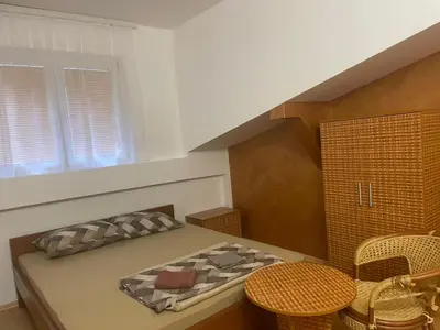 a small room with a bed and a table and chairs at Hostel Izvor in Podgorica