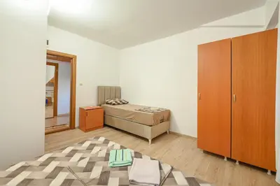 a bedroom with a bed and a wooden cabinet at Hostel Izvor in Podgorica