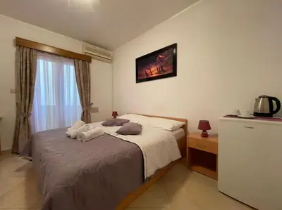 a bedroom with a bed and a tv on the wall at Apartments Stari Ribar in Budva