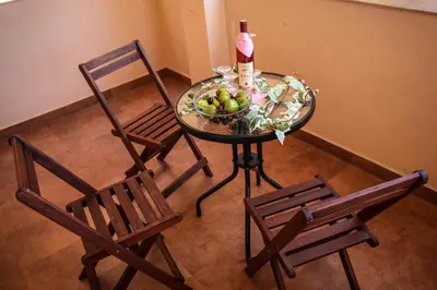 a table with a bottle of wine and two chairs at Apartments Stari Ribar in Budva